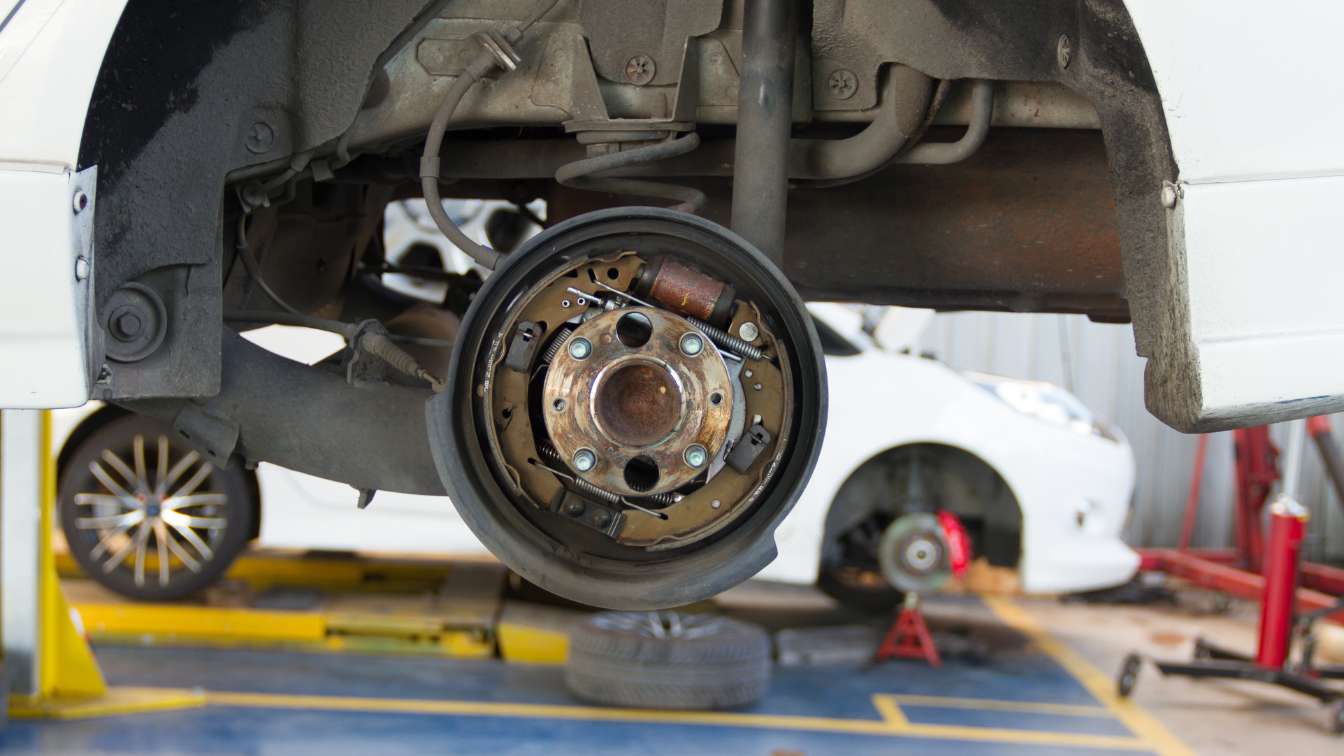 Vehicle on a lift with the rear brake assembly exposed